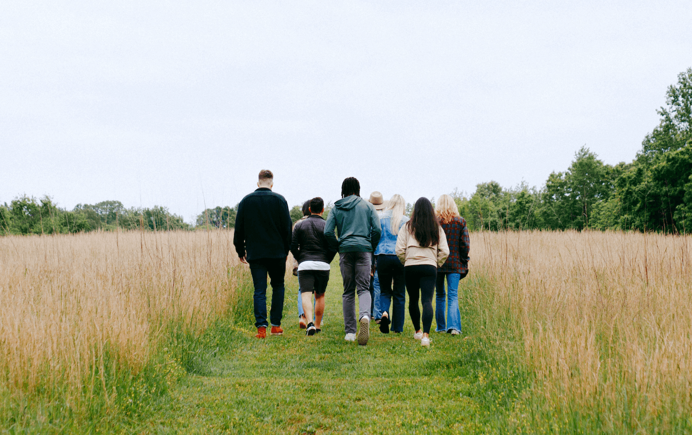 A group walking together along a path through a field.