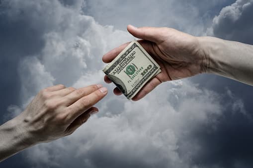 Money being exchanged during a discussion about religious giving.